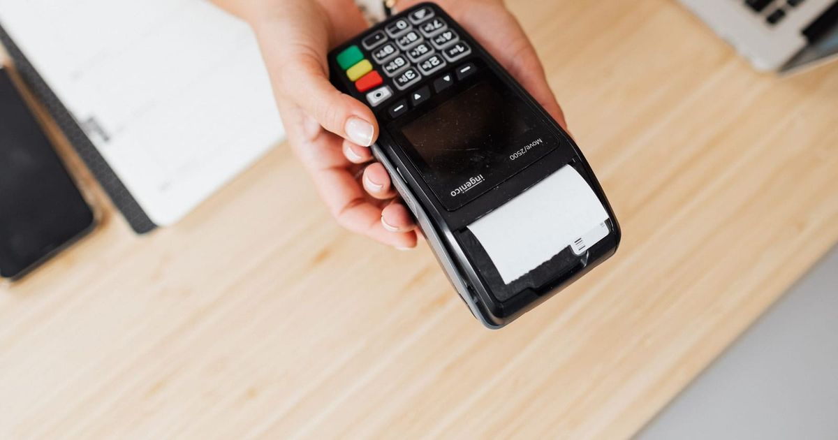 Card payment terminal held out with a printed receipt