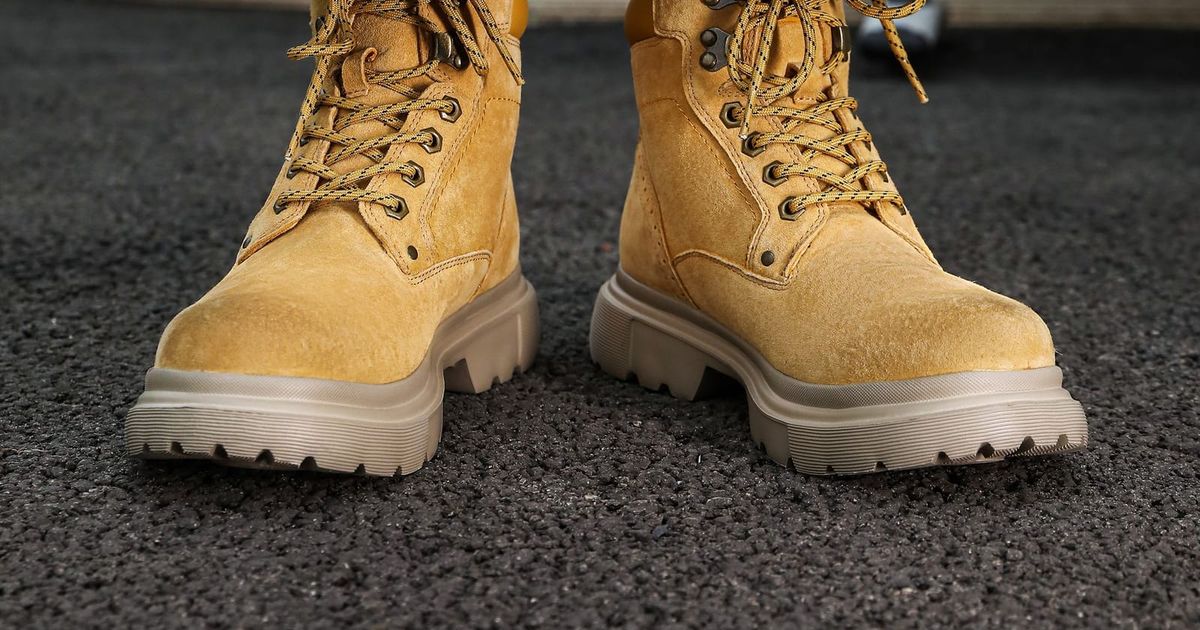 Pair of tan leather lace-up work boots on a dark floor