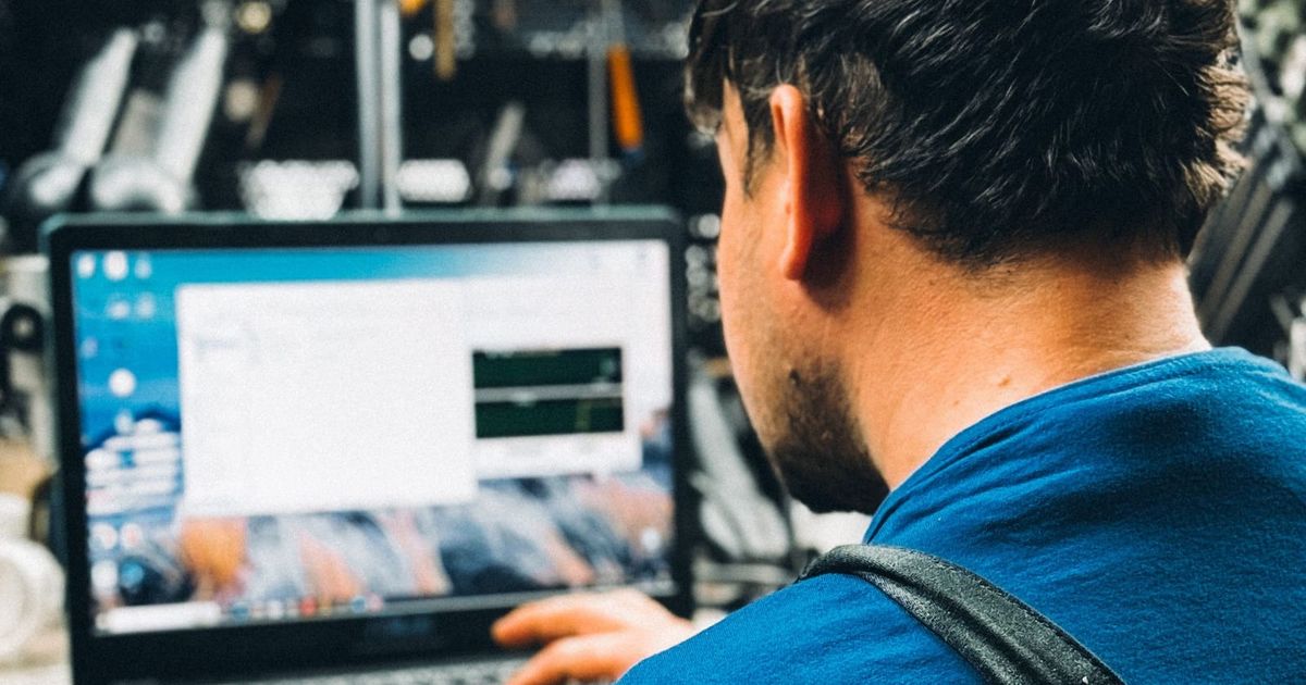 Technician working on a laptop in a workshop