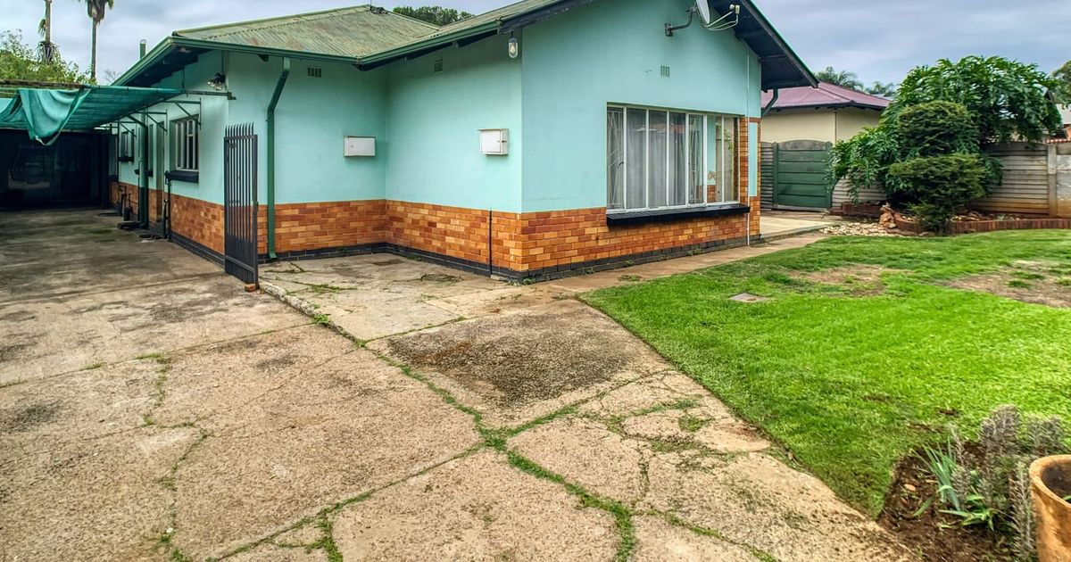 Brick and weatherboard house with a front lawn and driveway