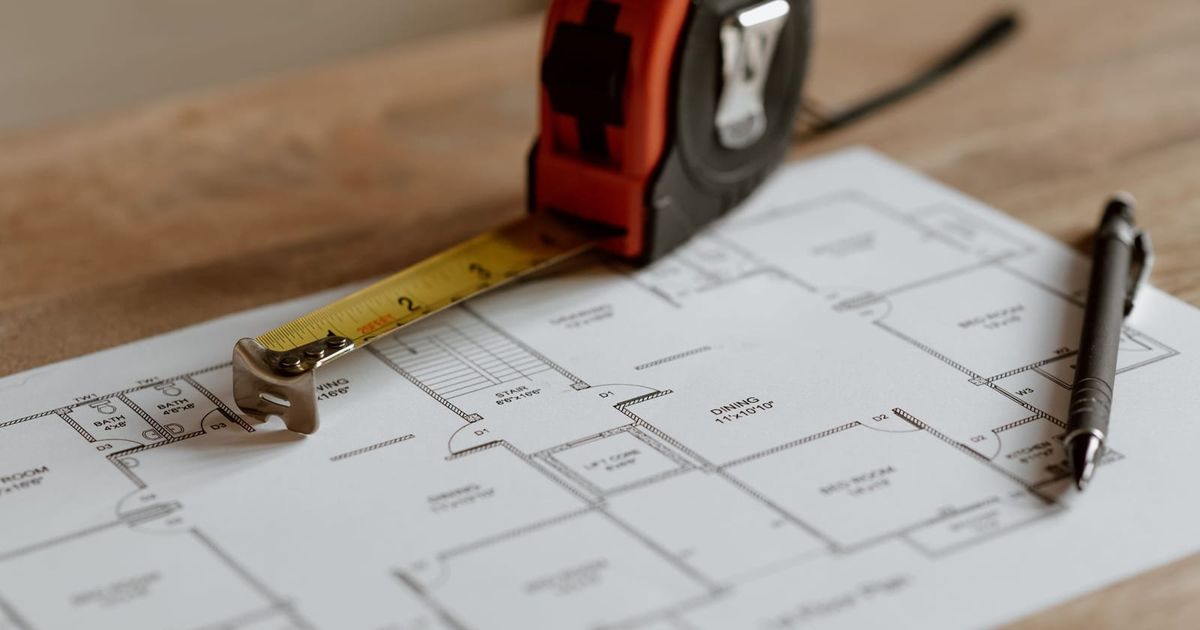 Floor plan, tape measure and pen laid out ready to price a job