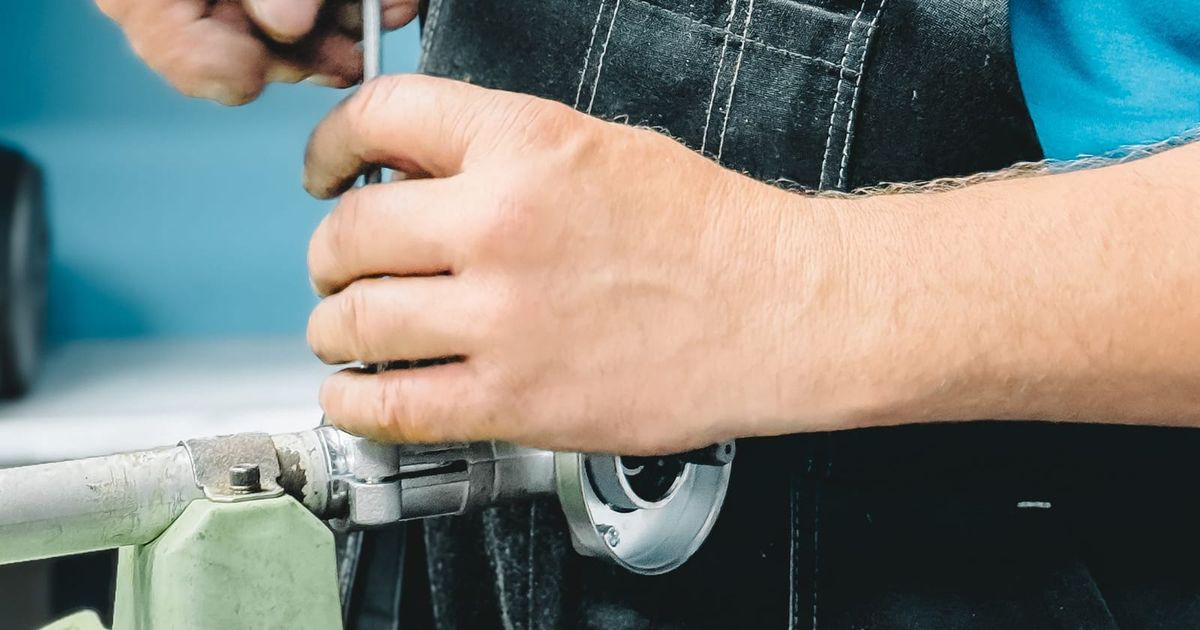 Plumber tightening a pipe fitting with a wrench