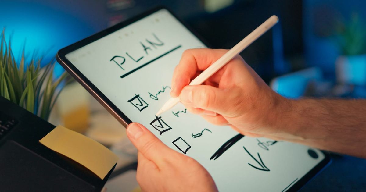 Hand planning a task list on a tablet with a stylus